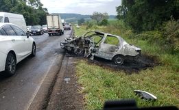 Carro pega fogo após colisão com caminhão e quatro pessoas ficam feridas