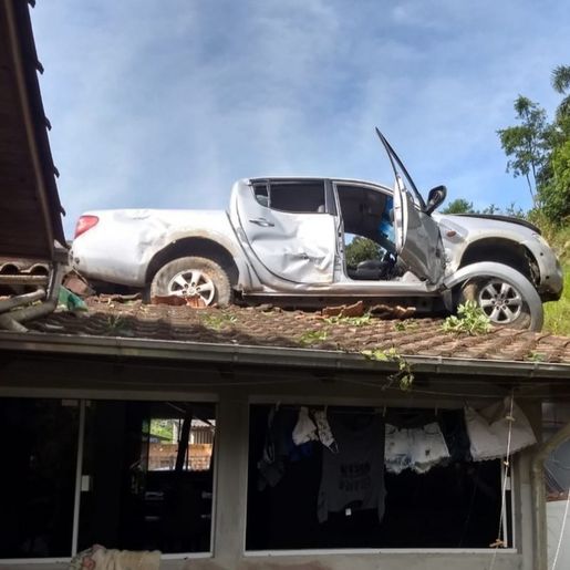Camionete para em cima de residência após acidente