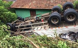 Motorista perde o controle da direção, tomba caminhão e por pouco não atinge residência