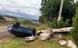 Veículo sai da pista, bate em poste e capota no interior
