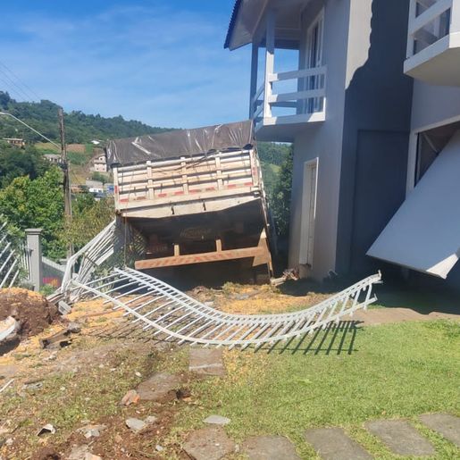 Condutor perde controle e caminhão invade pátio de residência