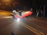 Motorista colide em carro estacionado, capota veículo e foge a pé