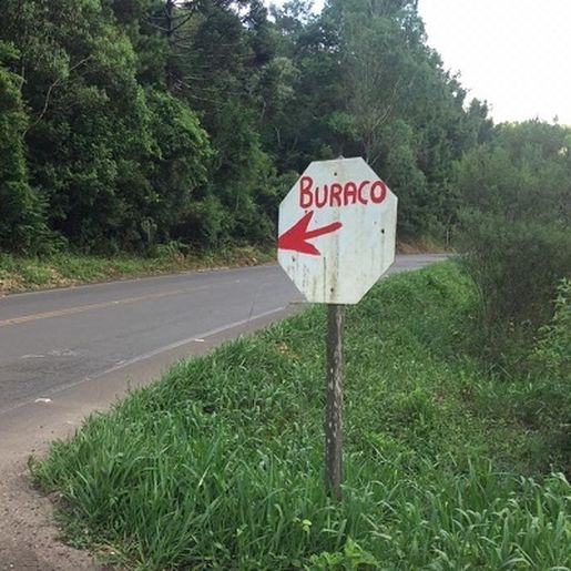 Usuário faz placa à mão indicando buraco na pista e evita acidentes