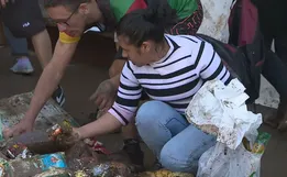 Moradores pegam alimentos da lama após passagem de ciclone no RS